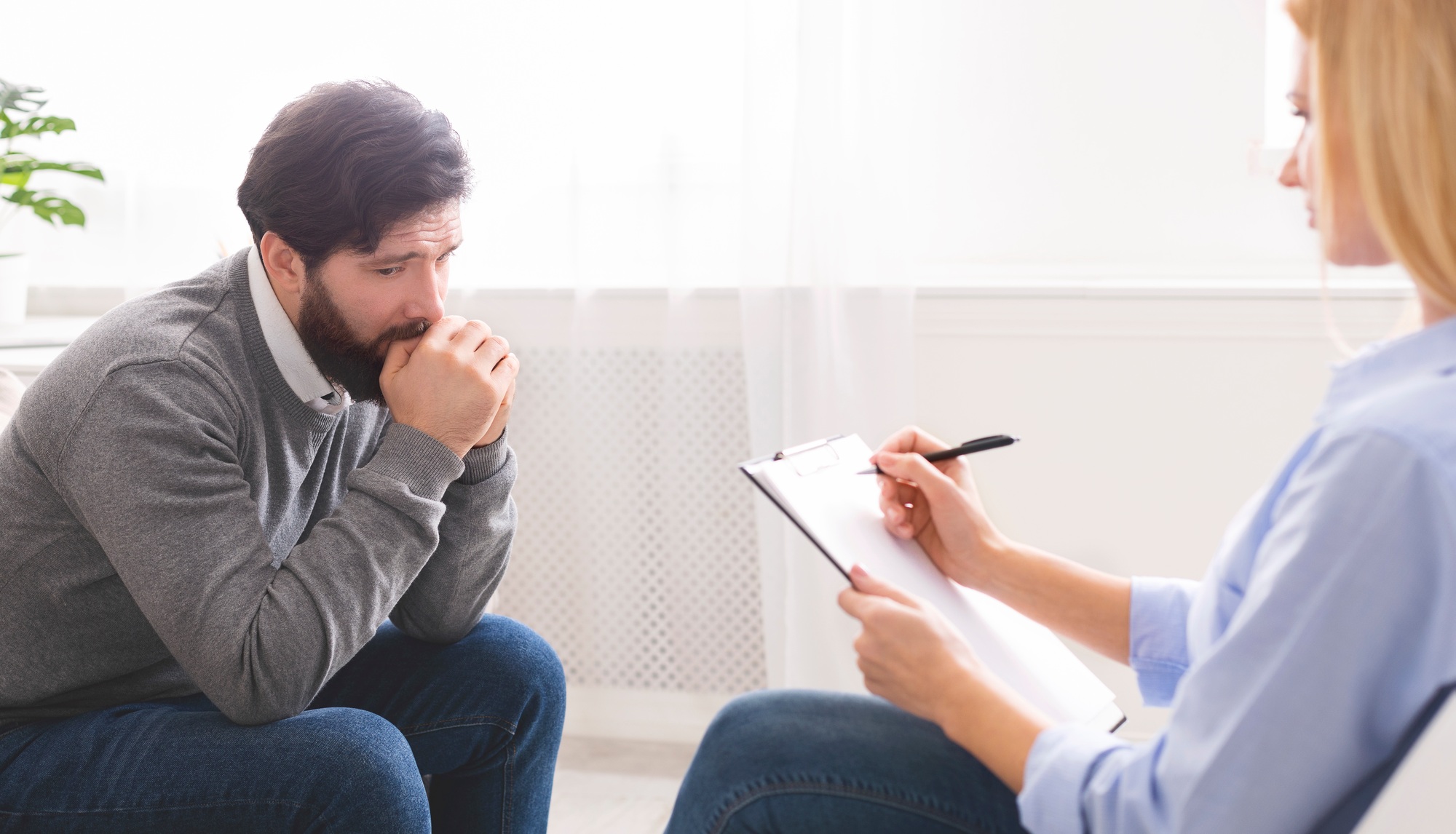 Depressed man getting psychological treatment at office
