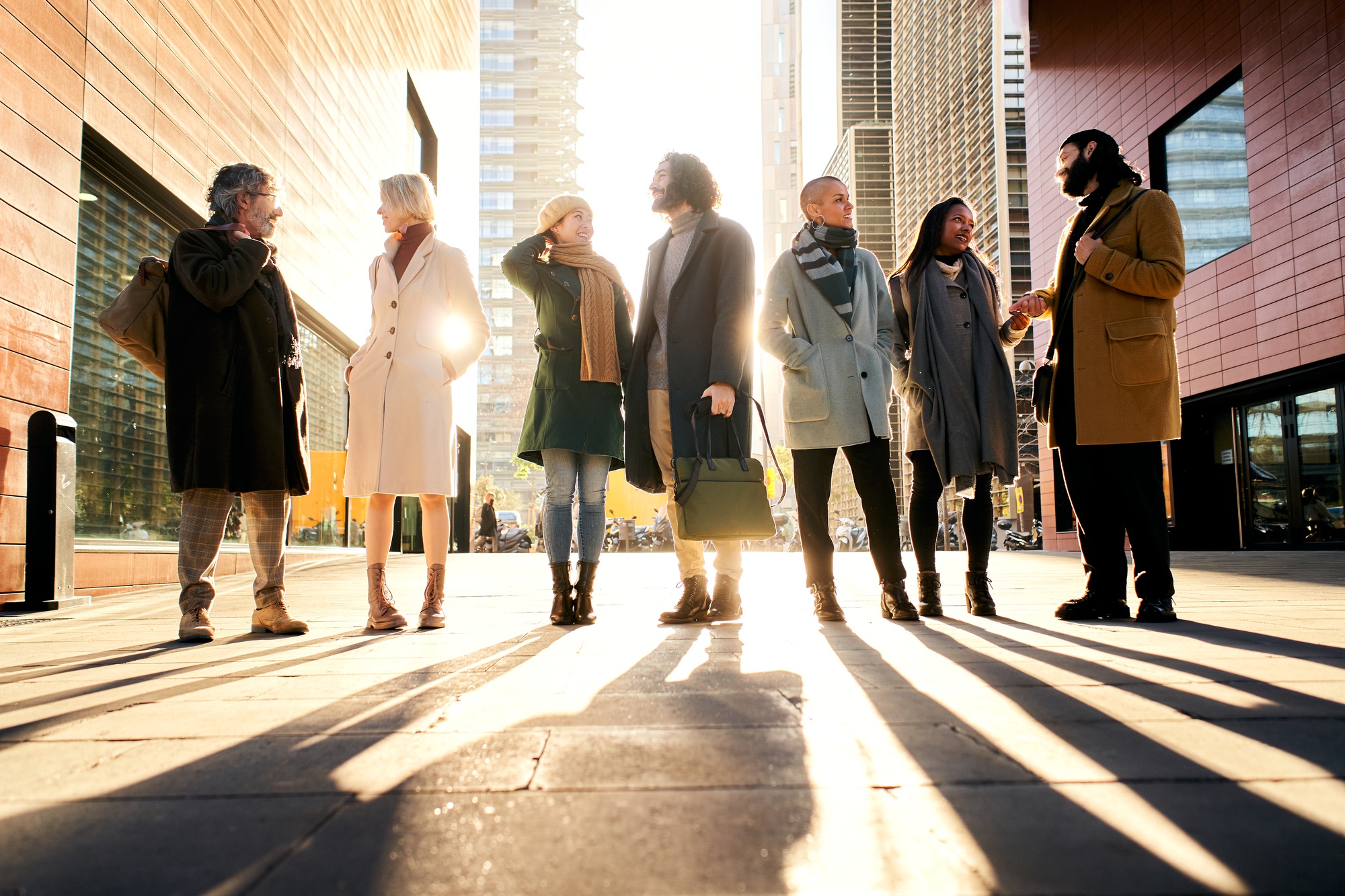 Silhouette of a group of business people full body talking outdoors in the city street